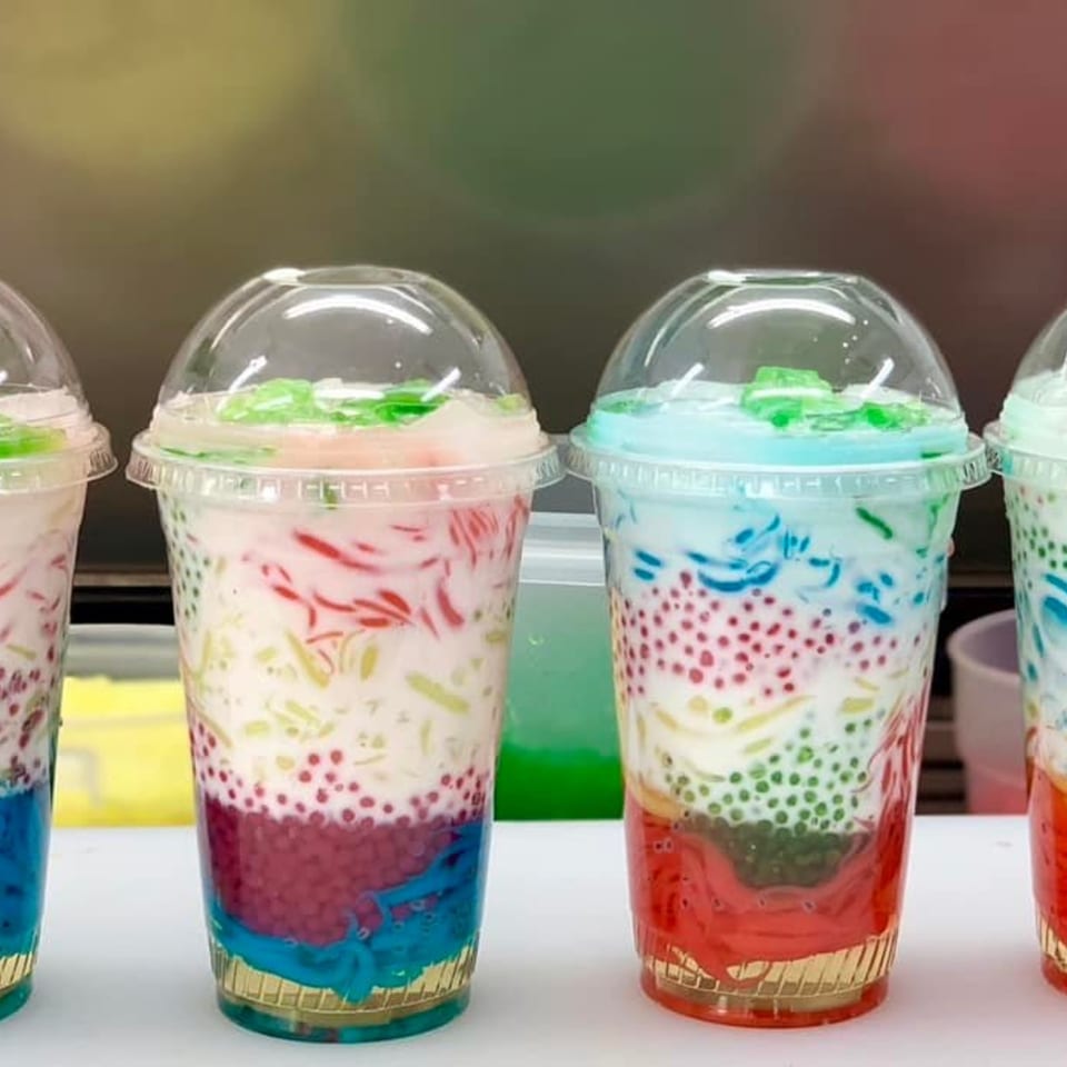 Four colorful Hmong desserts in clear cups with layered tapioca, jellies, and coconut milk.